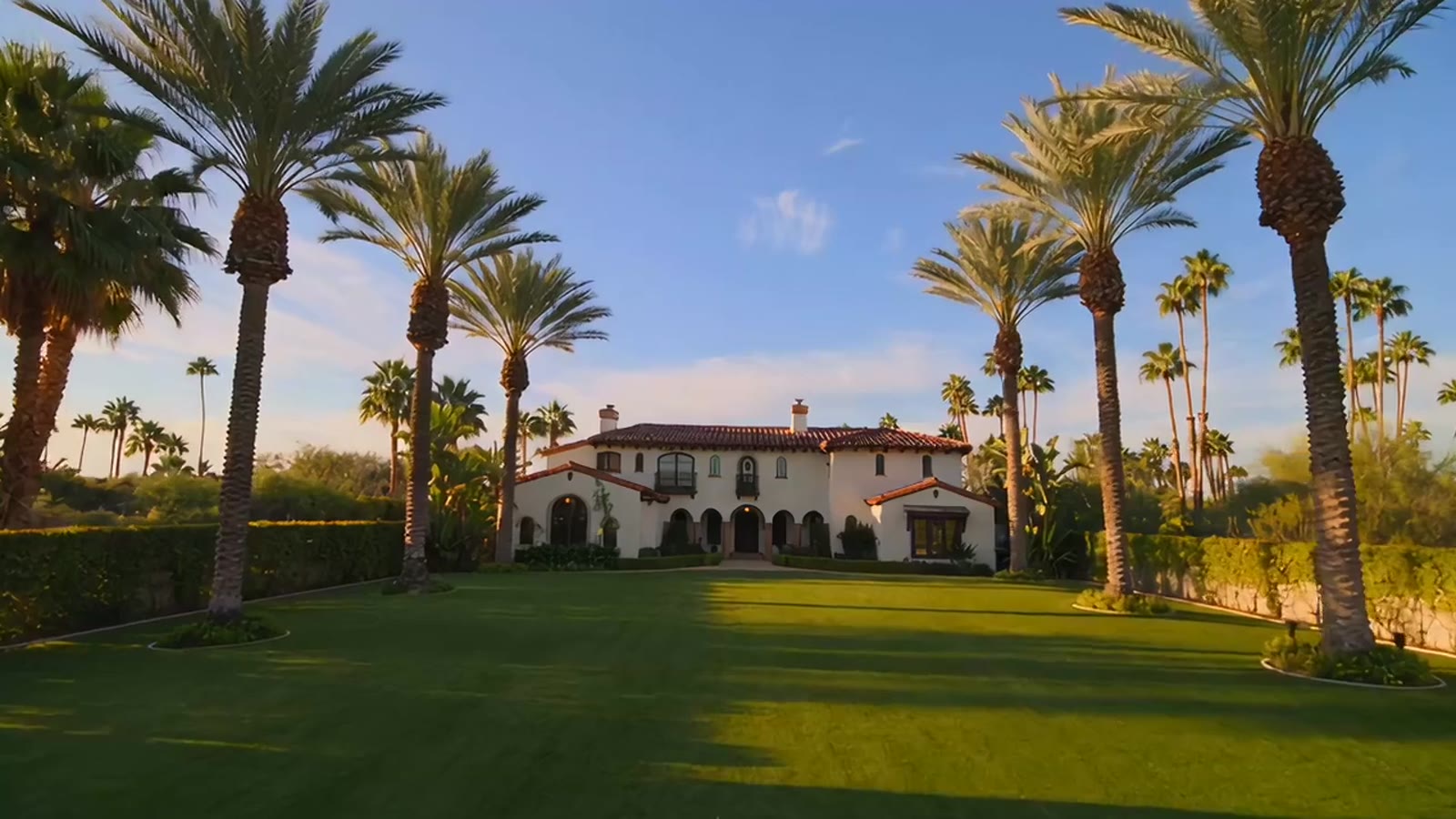 White Spanish-style home with clay tile roof and palm trees, illustrative